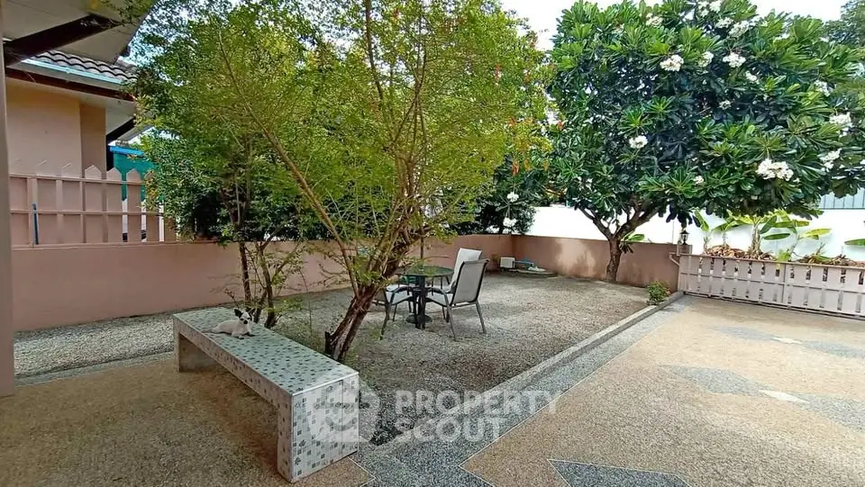 Charming garden area with seating and lush greenery in a serene residential setting.