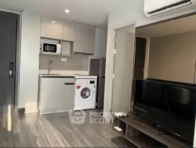 Modern apartment interior with kitchen and living area featuring sleek appliances and stylish decor.