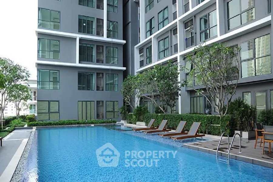 Modern apartment complex with inviting outdoor pool and lush greenery.