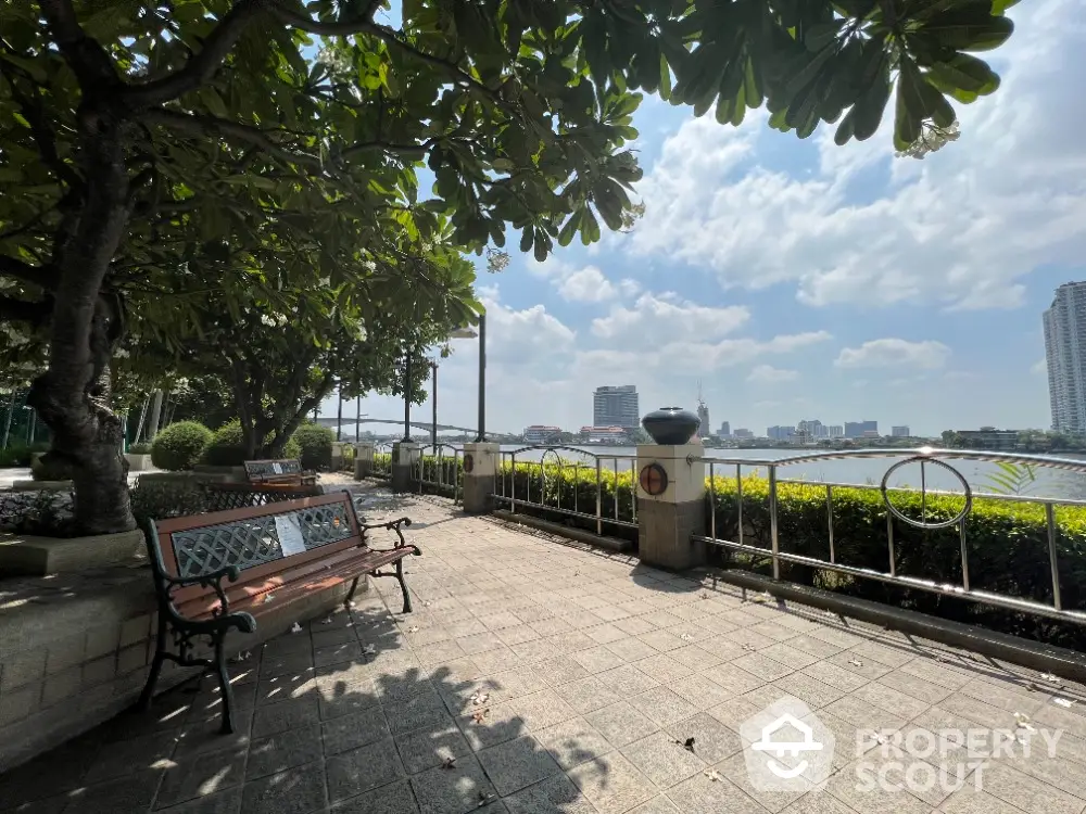 Scenic riverside view with lush greenery and city skyline, perfect for relaxation and leisure.