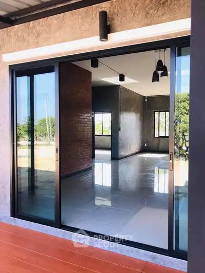 Modern interior with large sliding glass doors and polished floors, offering a bright and open living space.