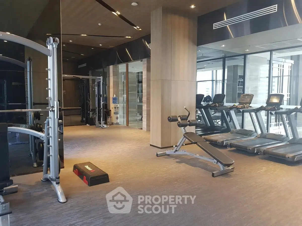Luxurious modern gym with state-of-the-art equipment and sleek design in upscale residential building.