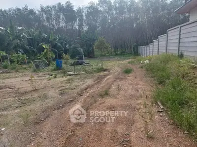 Spacious vacant land with lush greenery and potential for development.