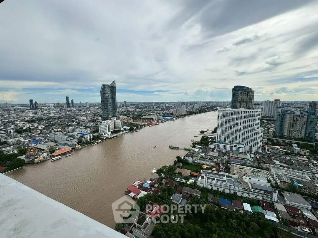 Stunning high-rise river view of cityscape with modern buildings and cloudy sky.