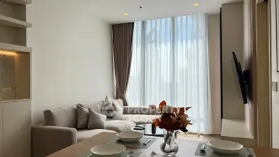 Modern living room with large windows and elegant decor in a high-rise apartment.