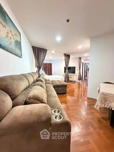 Spacious living room with plush sofa and wooden flooring in modern apartment