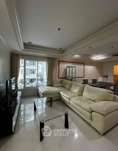 Spacious living room with elegant furniture and large window view.