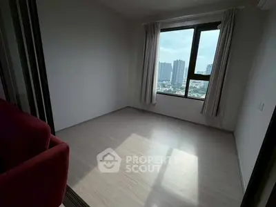 Spacious empty room with large window offering city view, perfect for customization.