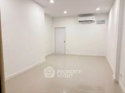 Spacious empty room with glossy tiled floor and air conditioning, perfect for customization.