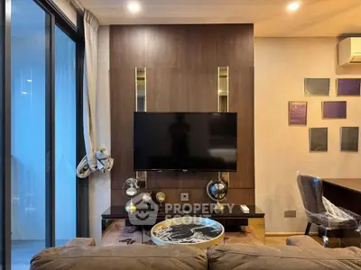 Modern living room with stylish decor and large TV, featuring elegant lighting and a cozy atmosphere.