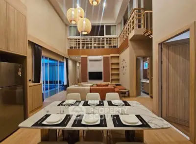 Luxurious open-plan living and dining area with high ceilings and modern decor.