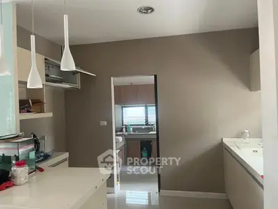 Modern kitchen with sleek design and open layout, featuring pendant lighting and ample storage space.