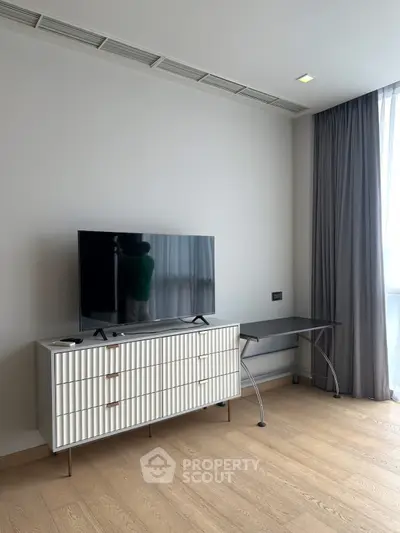 Modern living room with sleek TV stand and large window for natural light