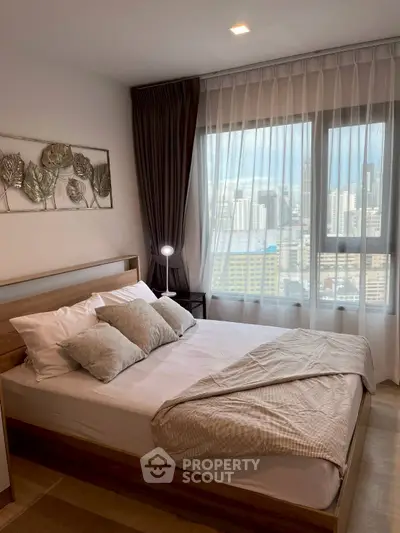 Modern bedroom with city view, featuring stylish decor and natural light.