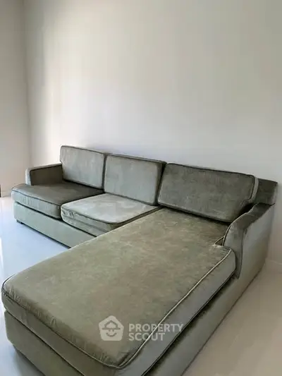 Spacious living room with modern gray sectional sofa and minimalist design.