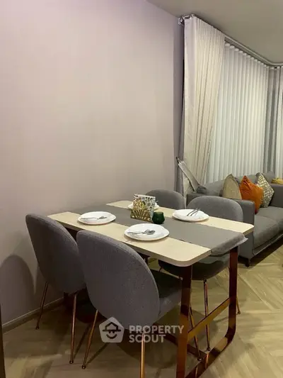 Modern dining area with stylish table and chairs in a cozy living room setting.