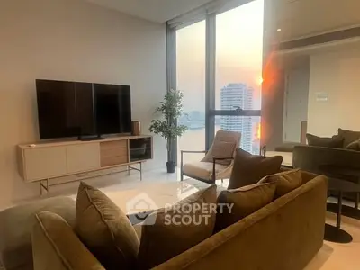 Luxurious living room with modern furniture and stunning city view at sunset.