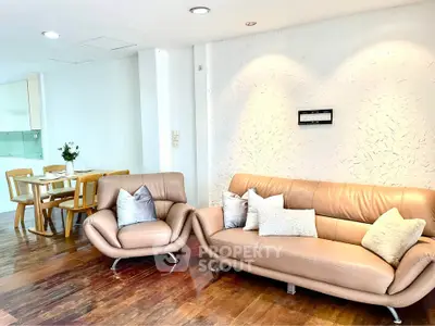Spacious living room with modern leather furniture and elegant dining area in open layout.