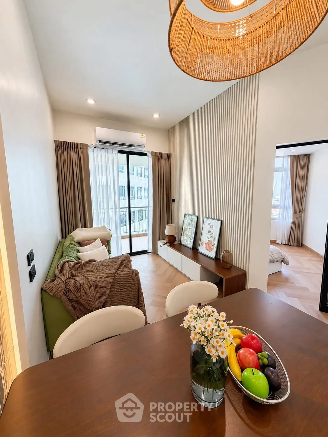 Modern living room with stylish decor and natural light, featuring a cozy seating area and elegant dining space.