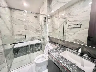 Luxurious modern bathroom with marble finishes and glass shower enclosure