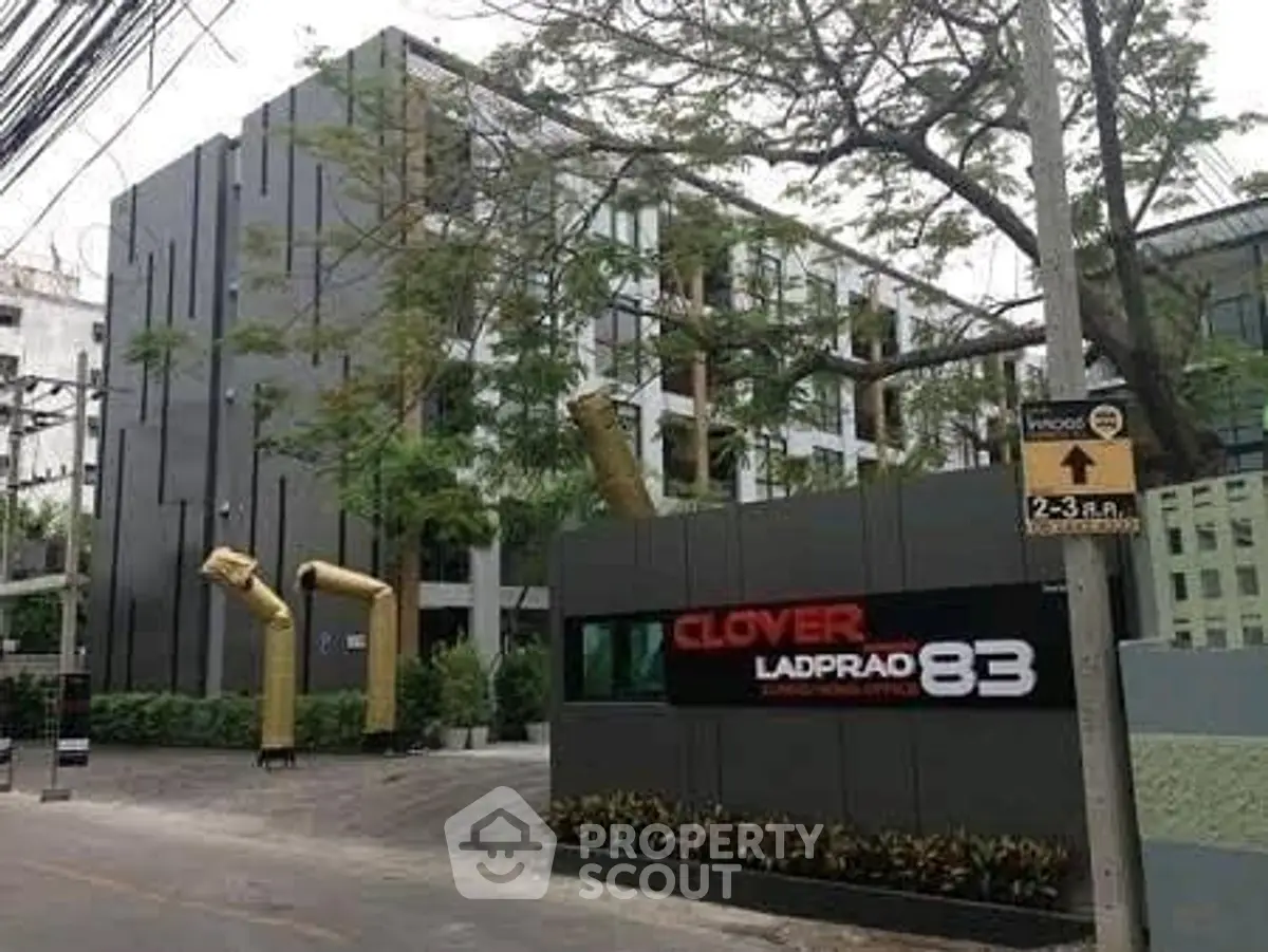 Modern apartment building exterior with lush greenery and stylish facade in urban setting.