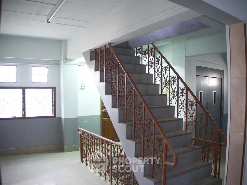 Spacious building interior with elegant staircase and elevator access, ideal for modern living.