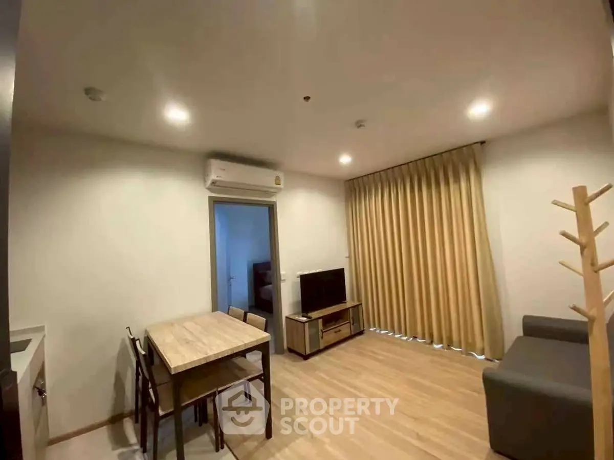 Modern living room with dining area, featuring sleek furniture and ambient lighting.