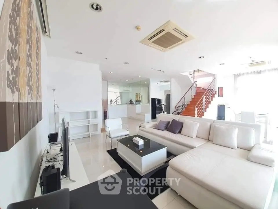 Spacious modern living room with white sectional sofa and elegant decor