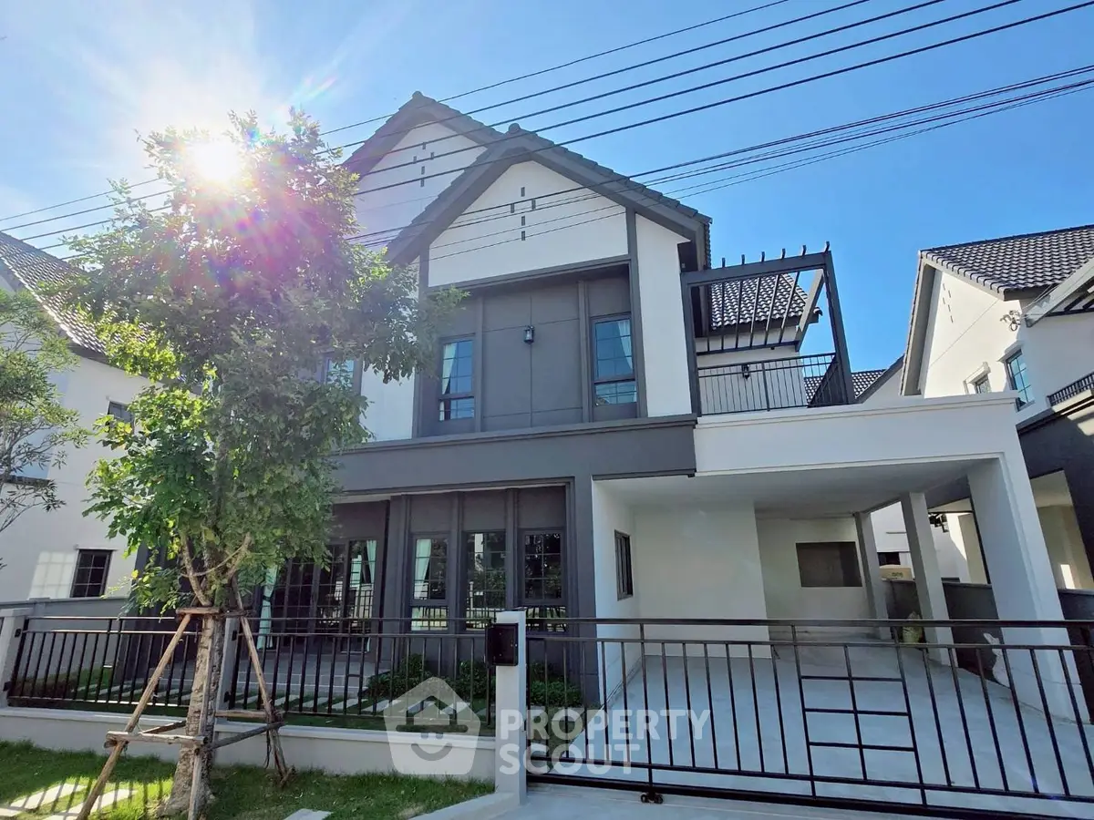 Modern two-story house with sleek design and spacious driveway in a sunny neighborhood.