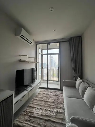 Modern living room with balcony view, featuring sleek furniture and natural light.