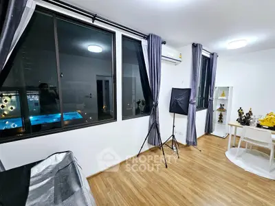 Modern living room with large windows and stylish decor, perfect for urban living.