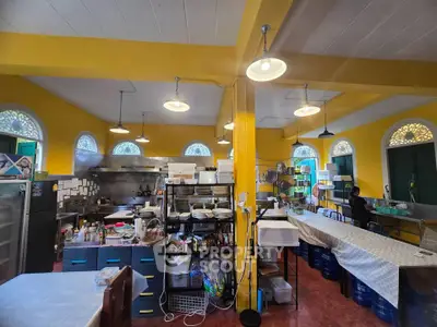 Spacious commercial kitchen with vibrant yellow walls and ample storage space.