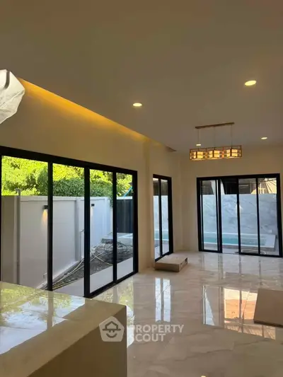 Spacious modern living room with large windows and marble flooring