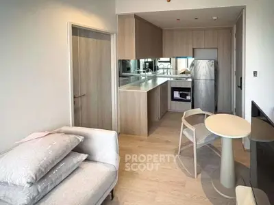 Modern open-layout kitchen with sleek appliances and cozy living area in a stylish apartment.