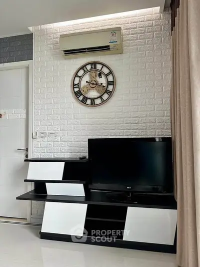 Modern living room with stylish TV stand, wall clock, and air conditioning unit.