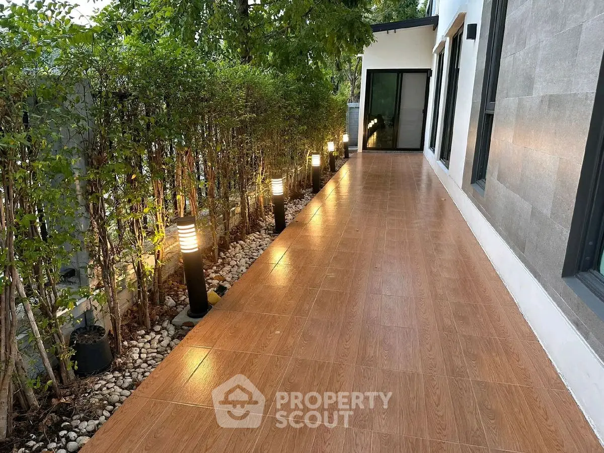 Elegant outdoor walkway with modern lighting and lush greenery