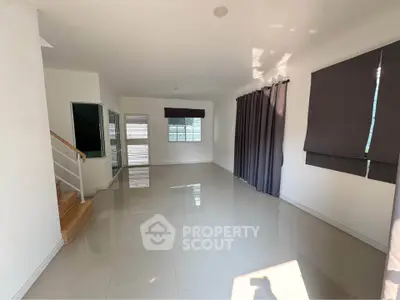 Spacious unfurnished living room with large windows and modern tile flooring.