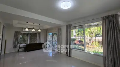 Spacious living room with large windows and garden view