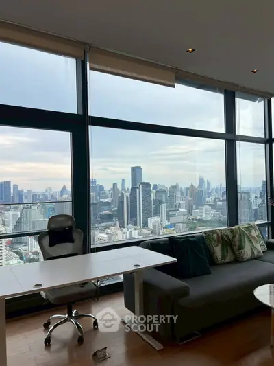 Stunning city view from modern high-rise apartment with floor-to-ceiling windows.