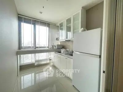 Modern kitchen with sleek white cabinets and large window view