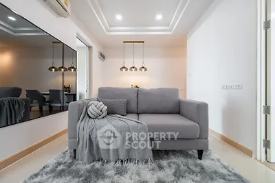 Modern living room with stylish gray sofa and elegant lighting in a contemporary apartment.