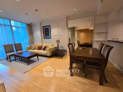 Spacious living room with elegant dining area and large windows in modern apartment.