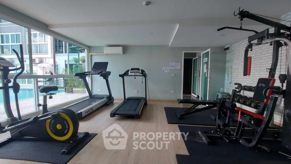Modern gym with pool view in luxury residential complex