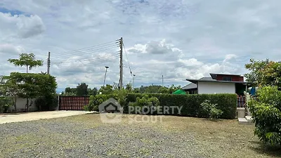 Spacious residential property with lush greenery and open sky views.