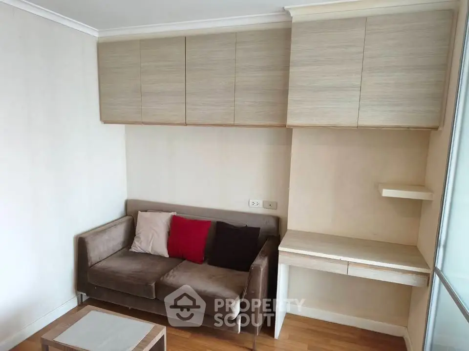 Cozy living room with modern sofa and built-in storage cabinets, perfect for compact urban living.