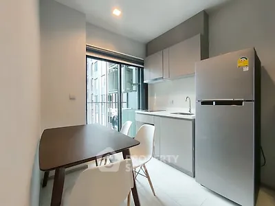 Modern kitchen with sleek design and stainless steel fridge in a compact space.