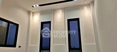 Modern interior with high ceilings and large windows, featuring elegant recessed lighting.