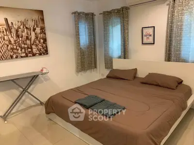 Cozy bedroom with modern decor and ironing board, perfect for comfort and convenience.
