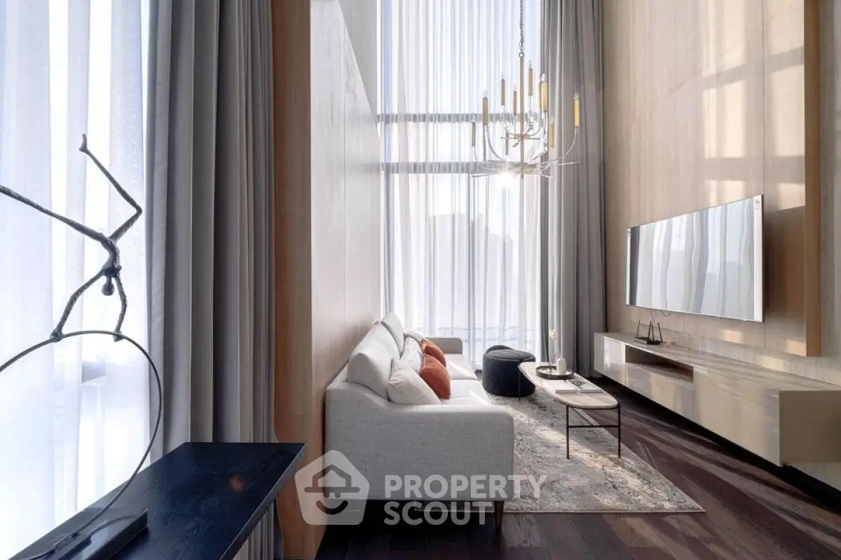 Luxurious high-ceiling living room with elegant decor and large windows.