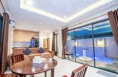 Luxurious open-plan living room with pool view and modern kitchen